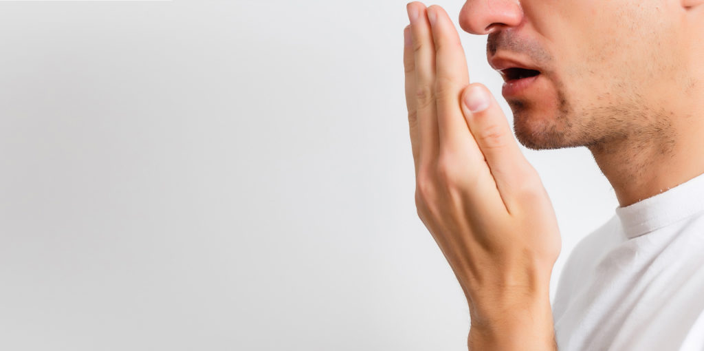 man checks for bad breath