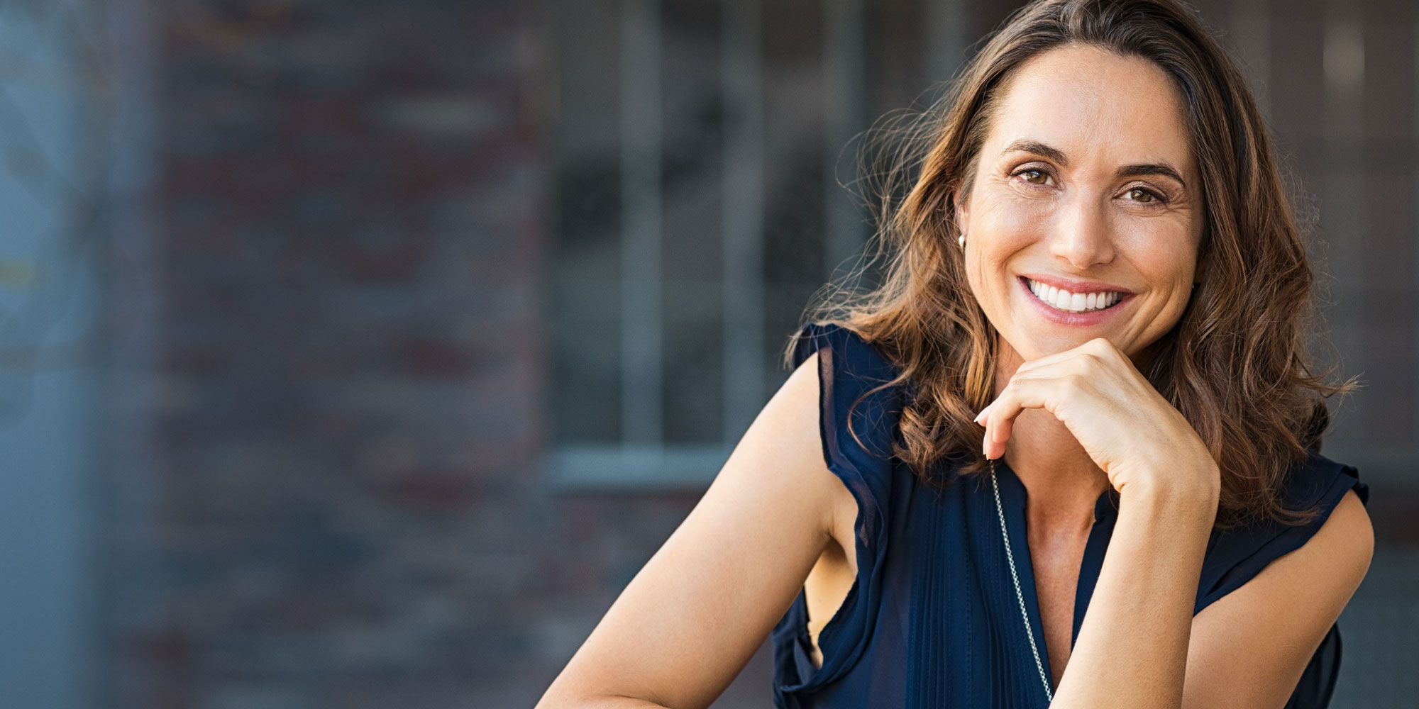 brunette woman in blue blouse smiles
