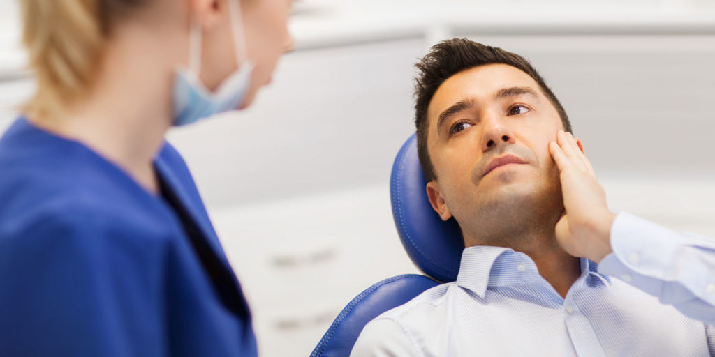 young man identifies dental pain to dentist