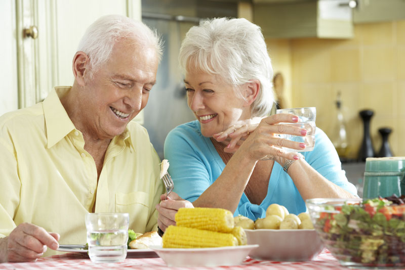 Dental Implant Patients Smiling While Eating Dinner