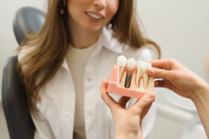 Dental Patient Getting Shown A Dental Implant Model During Her Consultation in Oakdale, PA