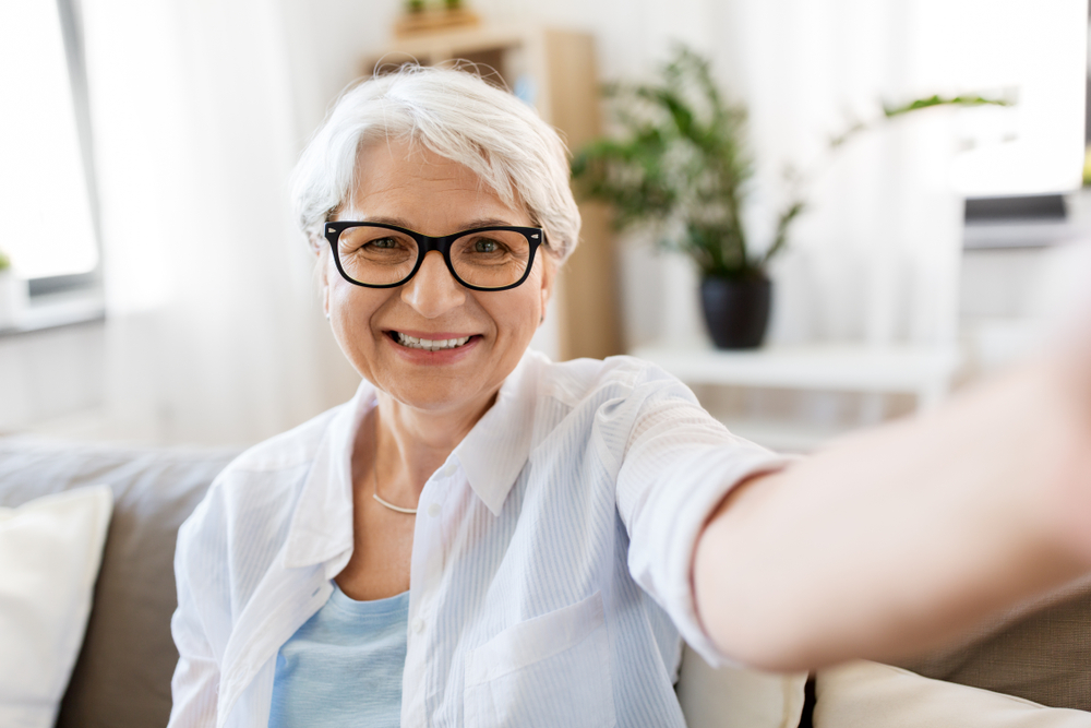 white haired older woman takes selfie