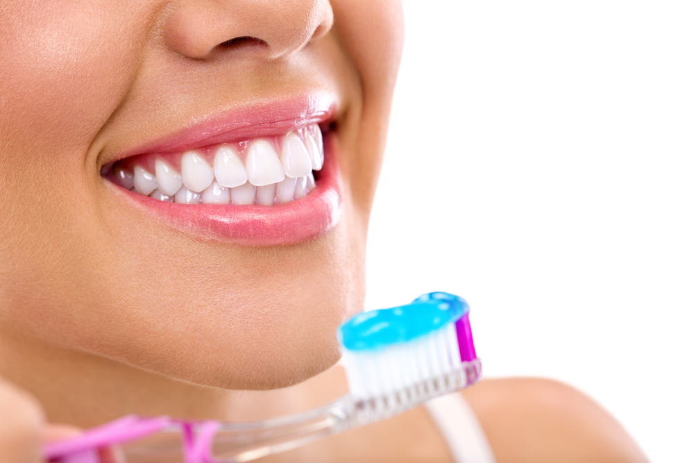 close up of a young woman about the brush teeth