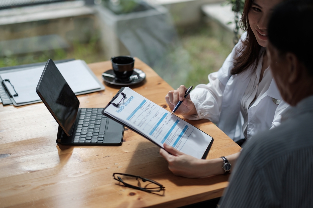 doctor reviews health insurance with patient